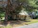 Charming single-story home with a front porch and mature trees providing shade at 2944 N Lookout St, Claremont, NC 28610
