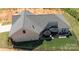 Aerial view of a home featuring a brick exterior, gray roof, patio, and fenced yard perfect for outdoor relaxation at 3006 Constitution Ln, Gastonia, NC 28056