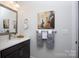 Well-lit half bathroom featuring modern fixtures, a decorative mirror, and stylish towel arrangement at 3006 Constitution Ln, Gastonia, NC 28056