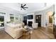 Cozy living room with a fireplace, large windows, modern ceiling fan, and hardwood floors at 3006 Constitution Ln, Gastonia, NC 28056