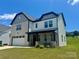 Beautiful two-story home with a brick and siding exterior, covered front porch, and manicured lawn at 305 Pleasant Hill Se Dr, Concord, NC 28025