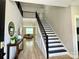 Inviting foyer with high ceilings, wood-look floors, and a staircase leading to upper level at 305 Pleasant Hill Se Dr, Concord, NC 28025