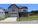 Two-story home with brick and siding exterior, a two-car garage, and landscaped front yard at 305 Pleasant Hill Se Dr, Concord, NC 28025