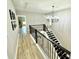 Bright hallway features modern chandelier, wood-look floors, and black metal staircase at 305 Pleasant Hill Se Dr, Concord, NC 28025