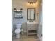 Stylish powder room with a modern vanity, elegant mirror, decorative shelves, and a toilet at 305 Pleasant Hill Se Dr, Concord, NC 28025