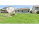Spacious backyard featuring green grass and a stone fire pit near the back of the home at 3296 Saddlebrook Dr, Midland, NC 28107