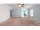 Spacious living room with plush carpeting, crown molding, and seamless flow into the breakfast nook at 3296 Saddlebrook Dr, Midland, NC 28107
