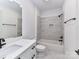 Modern bathroom with marble-look tile, white vanity, updated fixtures and shower-tub combination at 344 S Laurel Ave, Charlotte, NC 28207