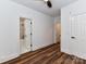 Cozy bedroom with a view of the ensuite bathroom and another room, wood-look flooring, and modern ceiling fan at 344 S Laurel Ave, Charlotte, NC 28207
