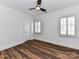A bright bedroom featuring modern ceiling fan, wood-look flooring and white trim around the windows and door at 344 S Laurel Ave, Charlotte, NC 28207