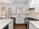 Well-lit kitchen showcasing white cabinets, stone countertops, stainless appliances, gold hardware, and plantation shutters for natural light at 344 S Laurel Ave, Charlotte, NC 28207
