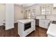 Open kitchen design with white cabinets, stainless steel appliances, kitchen island with microwave and beautiful hardwood floors at 344 S Laurel Ave, Charlotte, NC 28207