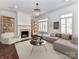 Bright living room with hardwood floors, fireplace, decorative shelving, and neutral colored furniture at 344 S Laurel Ave, Charlotte, NC 28207