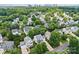 Aerial view of the neighborhood with lush tree coverage and skyline in the distance at 3535 Selwyn Farms Ln, Charlotte, NC 28209