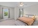 Cozy bedroom featuring neutral carpet, a ceiling fan and two bright windows at 3535 Selwyn Farms Ln, Charlotte, NC 28209