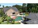 Aerial view of the backyard featuring pool, pool house, tanning ledge, and pristine landscaping at 3981 Spinnaker Pl, Denver, NC 28037