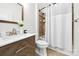 This bathroom features a modern vanity, brushed nickel fixtures, and a shower with a white curtain at 3981 Spinnaker Pl, Denver, NC 28037