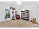 Sunlit bedroom with two windows, a cozy red chair, and a bookcase, offering a versatile space for relaxation at 3981 Spinnaker Pl, Denver, NC 28037