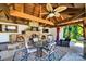 Inviting outdoor kitchen with a stone fireplace, TV, ceiling fan, and dining space for outdoor enjoyment at 3981 Spinnaker Pl, Denver, NC 28037