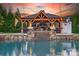 Stunning pool area with an outdoor kitchen and a stone fireplace that is perfect for entertaining guests at 3981 Spinnaker Pl, Denver, NC 28037