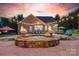 Exterior view showcases the pool, lounge chairs, outdoor kitchen, and fire bowls lit at dusk at 3981 Spinnaker Pl, Denver, NC 28037