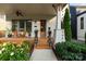 Inviting front porch with wood floors, chairs, and lush landscaping, providing a perfect spot for relaxation and outdoor enjoyment at 508 Mcalway Rd, Charlotte, NC 28211