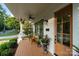 Close-up of front porch featuring wood floors, comfortable chairs, potted plants, and stylish details, perfect for relaxing outdoors at 508 Mcalway Rd, Charlotte, NC 28211