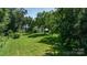 Expansive green backyard with mature trees providing ample shade and privacy at 5560 Springs Rd, Conover, NC 28613