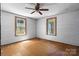 Bright bedroom featuring painted walls, wood floors, two windows, and ceiling fan at 5560 Springs Rd, Conover, NC 28613