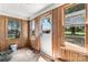 View of wood paneled entry with damaged door and windows, with view of buildings outside at 5560 Springs Rd, Conover, NC 28613
