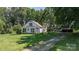 Exterior shot with sunroom, mature trees, and ample green space, offering a blend of comfort and rural charm at 5560 Springs Rd, Conover, NC 28613