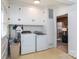 Bright laundry room with washer, dryer, and ample storage cabinets, creating functional space at 5727 Faulconbridge Rd, Charlotte, NC 28227