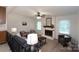 Comfortable living room featuring white painted walls, a ceiling fan, fireplace and easy access to kitchen at 5727 Faulconbridge Rd, Charlotte, NC 28227