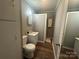 Compact bathroom featuring hardwood floors, sink, toilet, a shower, and mirror at 60 White Oaks Dr, Taylorsville, NC 28681