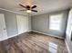 Cozy bedroom with hardwood floors, ceiling fan, closet, and bright window at 60 White Oaks Dr, Taylorsville, NC 28681