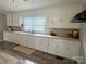 Kitchen featuring white cabinets, long countertop, a window with blinds, and hardwood floors at 60 White Oaks Dr, Taylorsville, NC 28681
