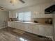 Kitchen with white cabinetry, long countertop, a window with blinds, and hardwood floors at 60 White Oaks Dr, Taylorsville, NC 28681
