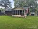 View of the spacious backyard, featuring a charming screened porch extension at 6039 Donna Dr, Charlotte, NC 28213