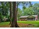 Expansive backyard featuring mature trees and a charming screened-in porch attached to a brick home at 6039 Donna Dr, Charlotte, NC 28213