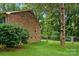 Backyard with brick house, chain-link fence, and mature trees at 6039 Donna Dr, Charlotte, NC 28213