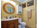 Bathroom featuring a wood vanity, round mirror, and decorative lighting at 6039 Donna Dr, Charlotte, NC 28213