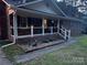 The covered front porch with classic brick, elegant railings, and manicured landscaping at 6039 Donna Dr, Charlotte, NC 28213