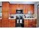 Compact kitchen features wood cabinets, appliances, and ample counter space for meal preparation at 6039 Donna Dr, Charlotte, NC 28213