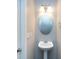 A half bath with a pedestal sink, round mirror and modern light fixture at 621 Pine Links Dr, Tega Cay, SC 29708