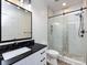 Modern bathroom with a black countertop, white vanity, and a glass-enclosed shower at 621 Pine Links Dr, Tega Cay, SC 29708