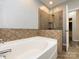 Bright bathroom featuring glass shower doors, decorative tile and tile surround and a soaker tub at 621 Pine Links Dr, Tega Cay, SC 29708