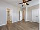 Empty bedroom with ceiling fan, wood flooring, an ensuite bathroom, and double closets at 621 Pine Links Dr, Tega Cay, SC 29708
