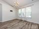Empty room with wood flooring and multiple windows with white blinds along with bracket to mount a television at 621 Pine Links Dr, Tega Cay, SC 29708