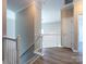 Upstairs hallway with wood flooring, white banister, and two bedroom entrances at 621 Pine Links Dr, Tega Cay, SC 29708