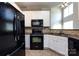 Cozy kitchen with black appliances, white cabinets, and a tiled backsplash at 621 Pine Links Dr, Tega Cay, SC 29708